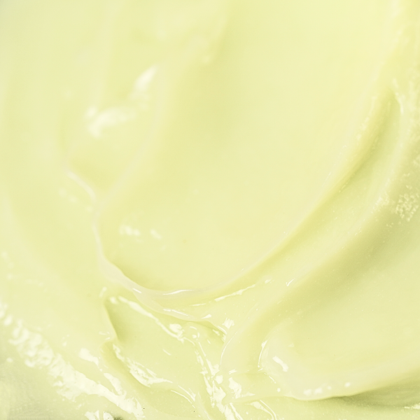 Thick, light green cream with a creamy texture and subtle ridges, giving a sense of its richness and density.